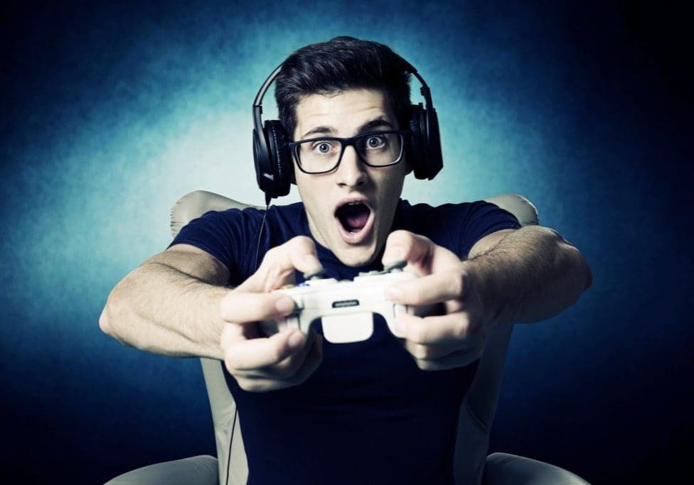 EUGameHost videogame addicted young guy playing with console .