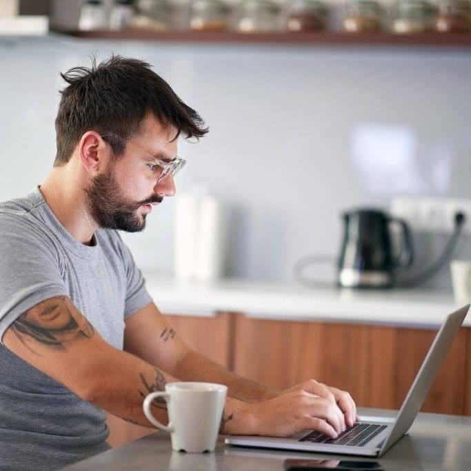 Sleepy  man  in the morning checking email on a laptop
