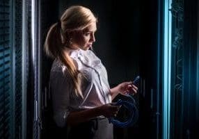 Young engineer businesswoman in network Server Security room.