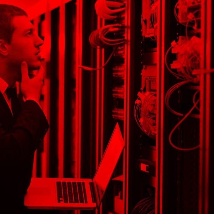 young engeneer business man with thin modern aluminium laptop in network server room