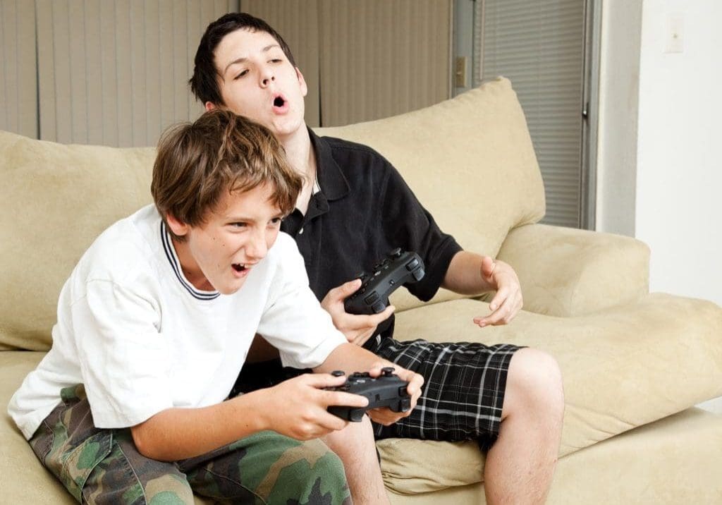UK Gaming Hosting Two boys playing video games with intense competition.