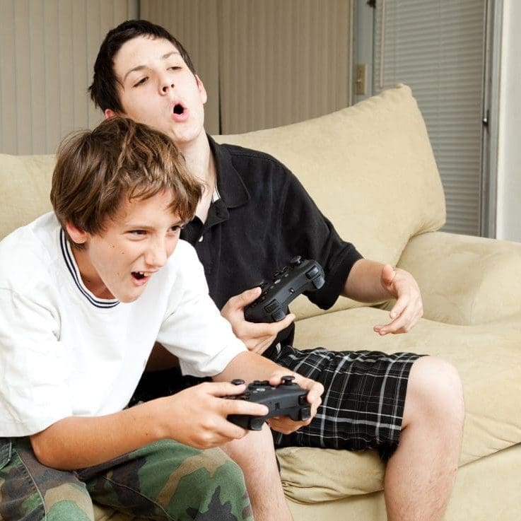 UK Gaming Hosting Two boys playing video games with intense competition.