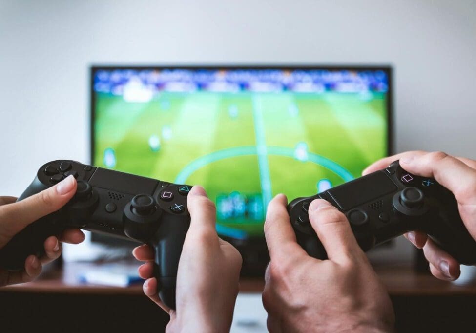 pexels-photo-442576 two people holding black gaming consoles