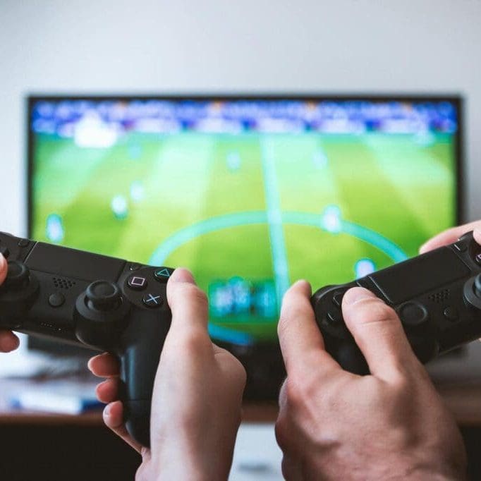 pexels-photo-442576 two people holding black gaming consoles